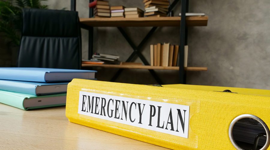 yellow binder in front of bookshelf about disaster emergency plan and security technology